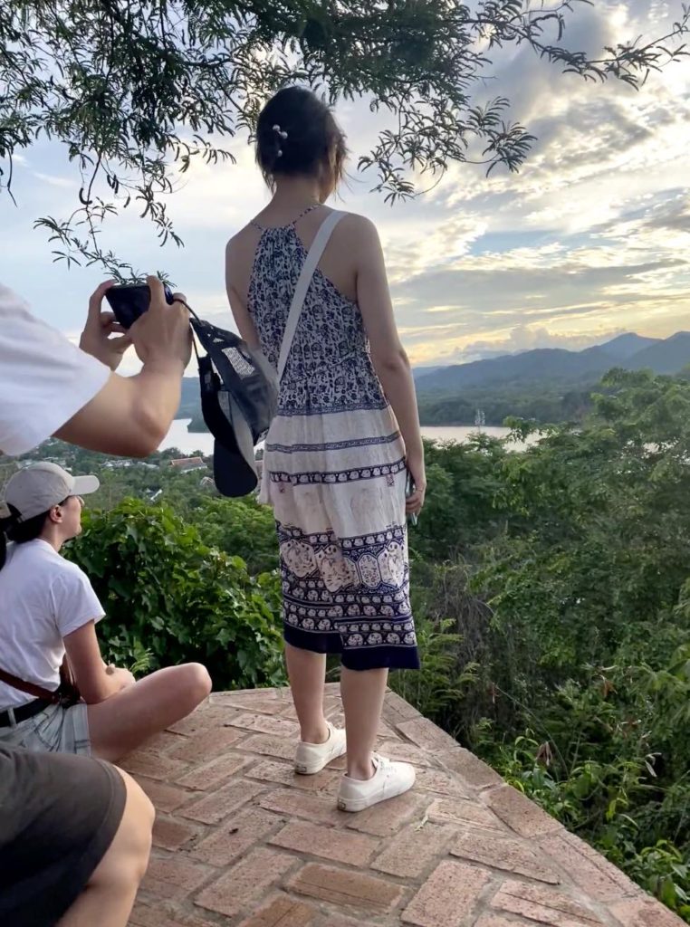 Woman being photographed at sunset, woman, Luang Prabang, temple, Luang Prabang sunset, Luang Prabang Laos